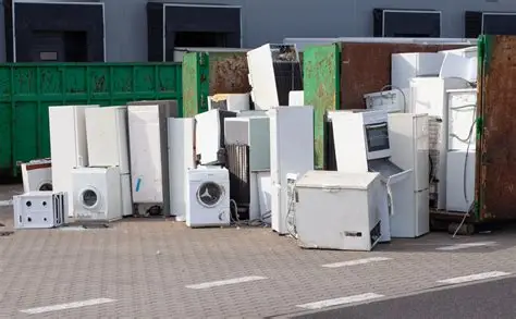 Difficult waste: Discarded appliances pile, including refrigerators, washing machines, and ovens. E-waste recycling.