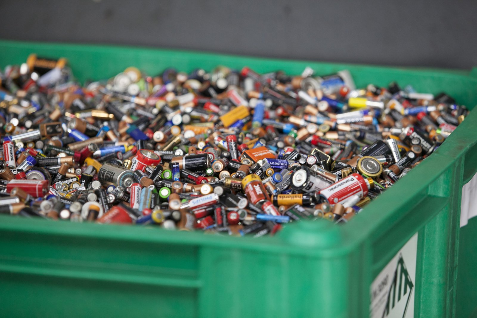 Recycling bin filled with used batteries. IL Battery Act compliance.