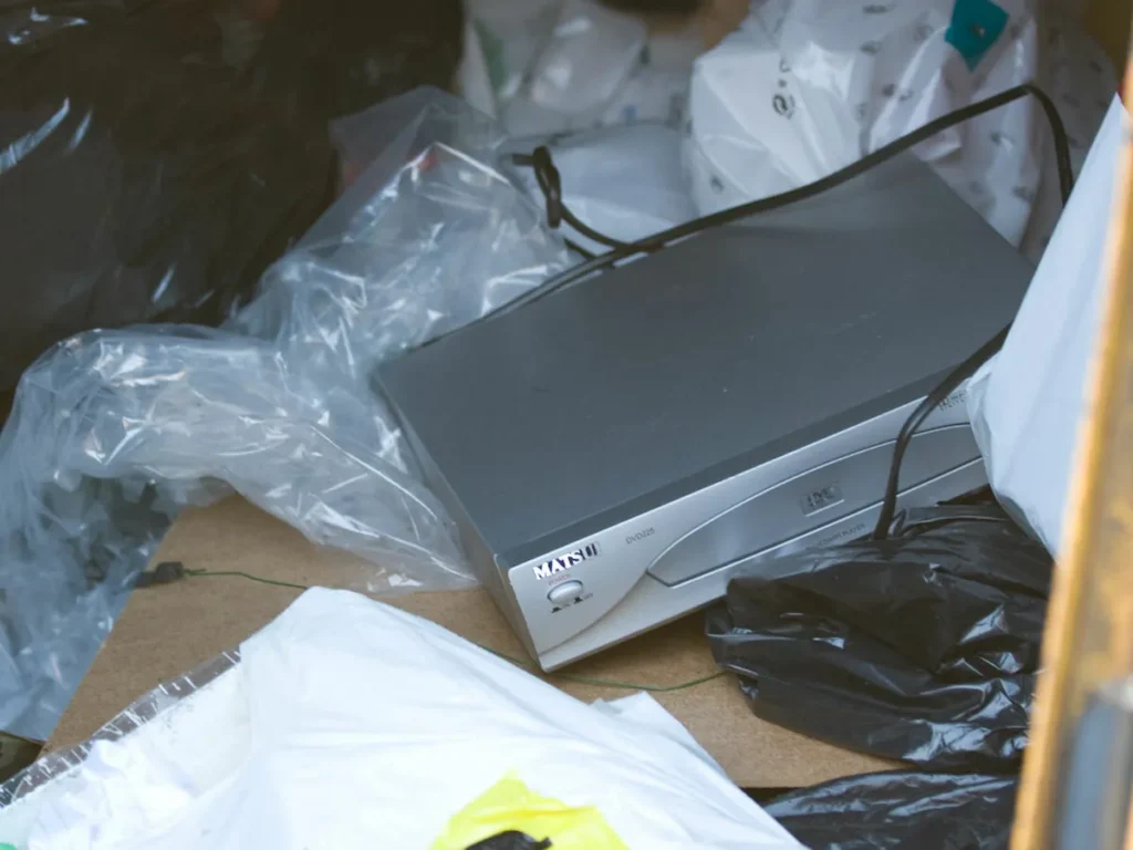Difficult waste: DVD player in trash. Electronic waste disposal. Recycling e-waste.