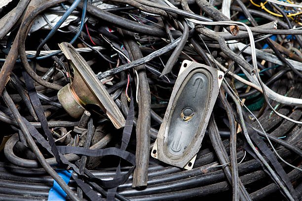 Difficult waste: Pile of discarded electronics, including wires and speakers. E-waste recycling concept.