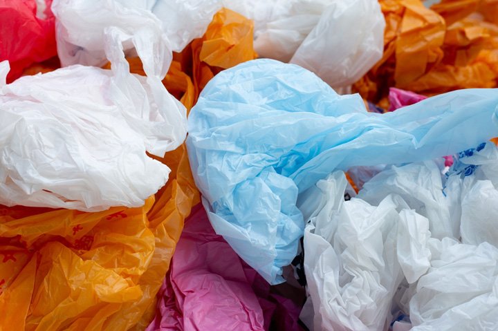 Pile of colorful, single-use plastic bags. Difficult waste, environmental pollution.