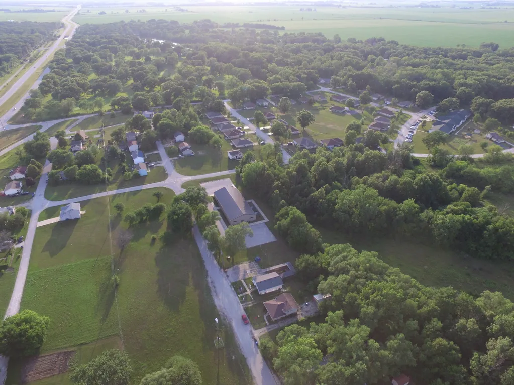Service area aerial view. Houses, trees, and roads in a rural landscape.